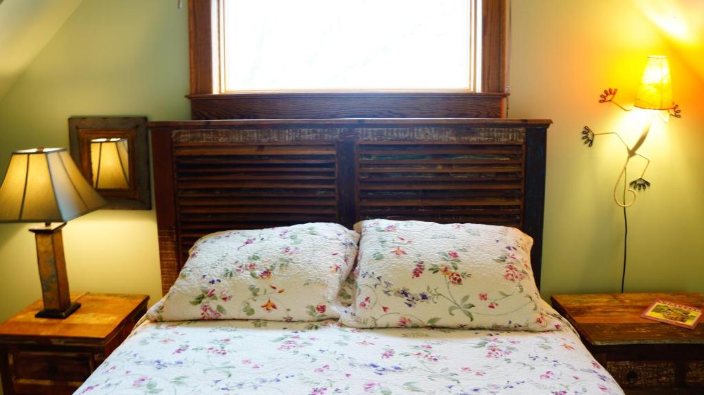 a bedroom with a bed with two pillows and a window at Stone Hill Overlook in Hermann