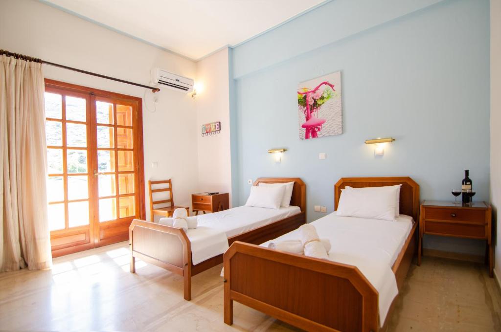 a bedroom with two beds and a window at Almira Inn in Ios Chora