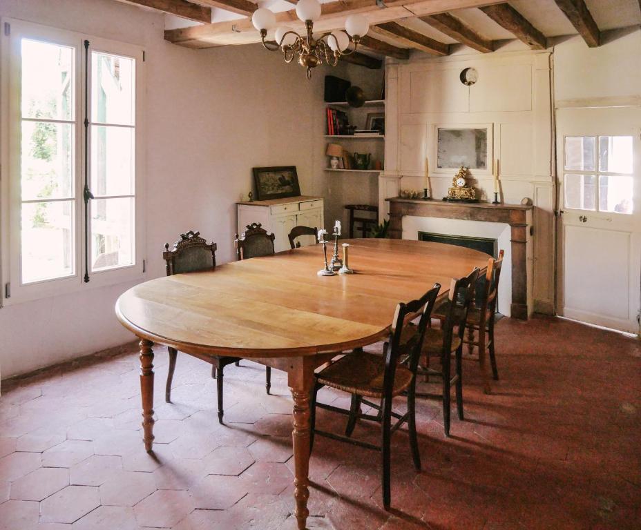 a dining room with a large wooden table and chairs at La Maison Pieuse in Villiers-Saint-Benoît