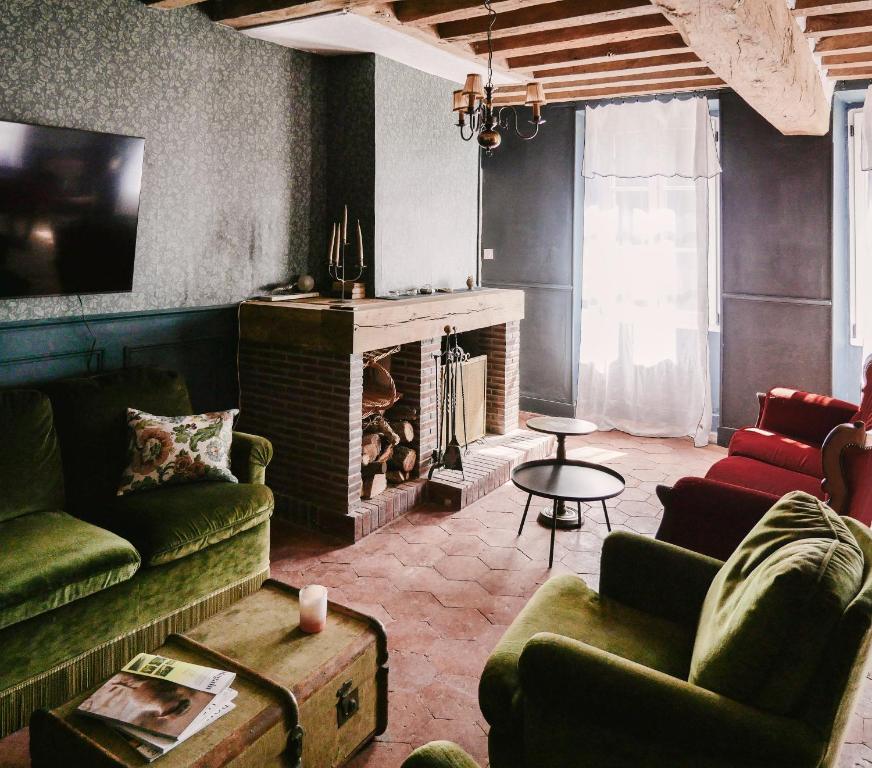 a living room with couches and a fireplace at La Maison Pieuse in Villiers-Saint-Benoît