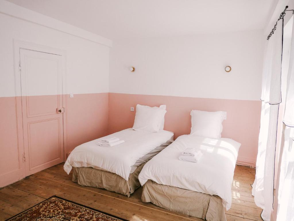 two beds sitting next to each other in a room at La Maison Pieuse in Villiers-Saint-Benoît