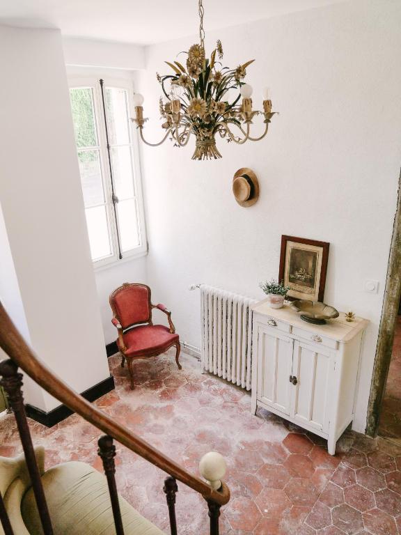 a room with a chair and a chandelier at La Maison Pieuse in Villiers-Saint-Benoît