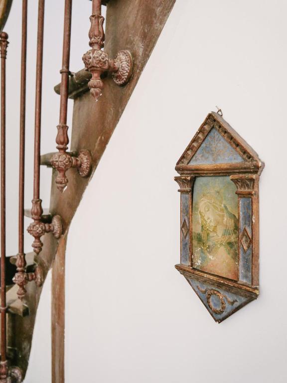 a clock hanging on the side of a staircase at La Maison Pieuse in Villiers-Saint-Benoît