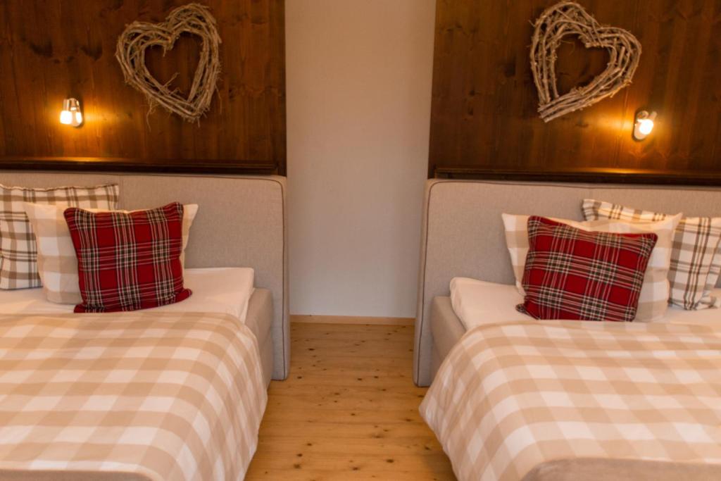 two beds in a room with hearts on the wall at Hof Timmermann - Bienenstock in Ottenstein