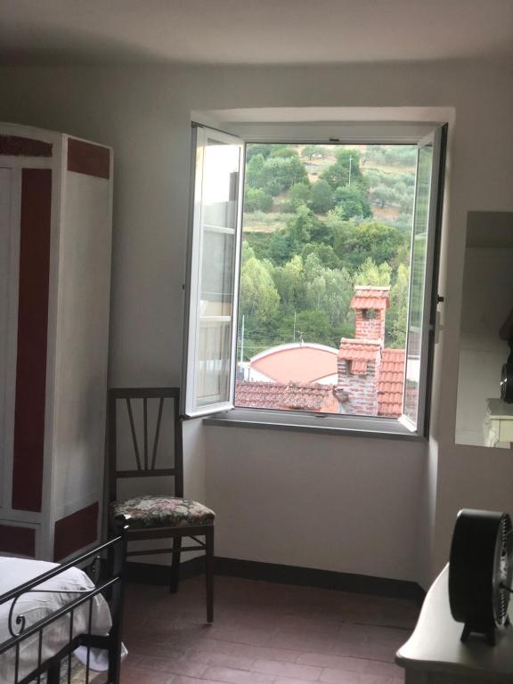 a bedroom with a large window and a chair at Casa Garibaldi in Pontremoli