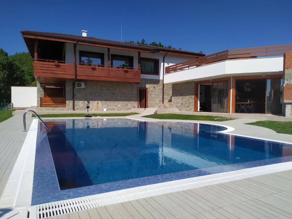 una casa con piscina frente a una casa en Вила БОЛЯРКА - РЕЛАКС en Glavatartsi