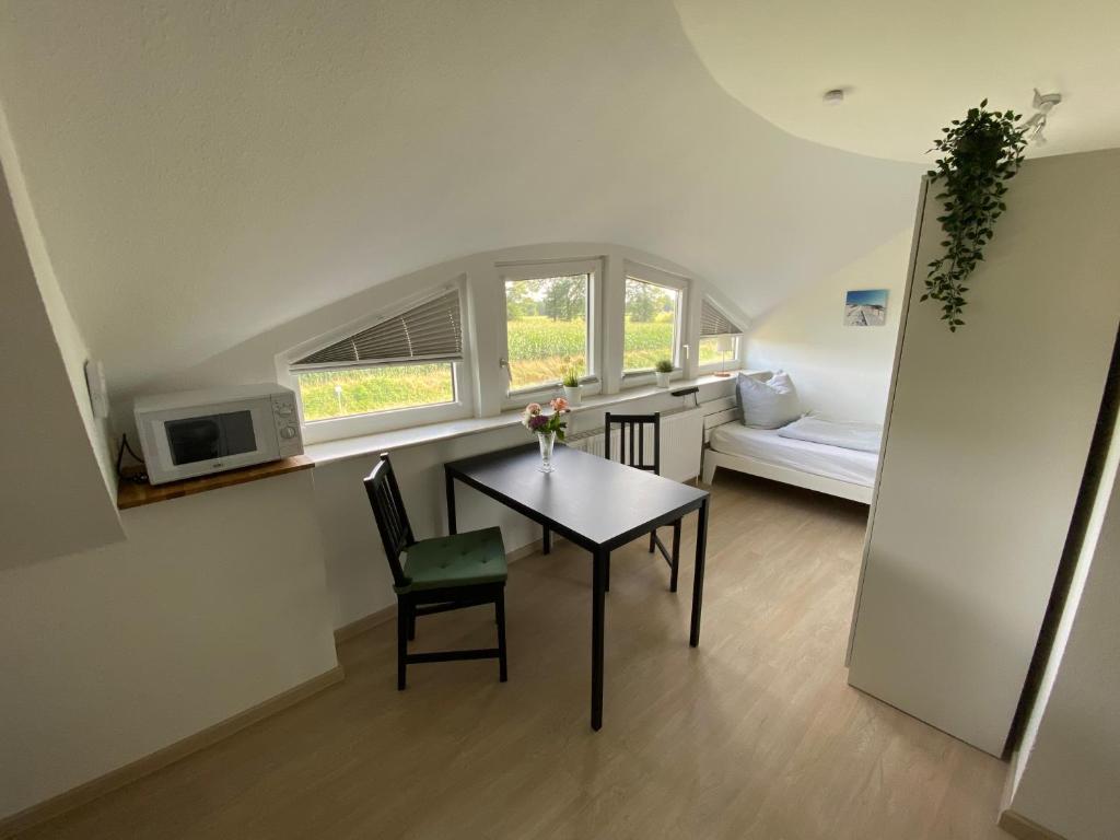 ein Esszimmer mit einem Tisch und einem Fenster in der Unterkunft Etzel-Lodge Feldblick in Friedeburg