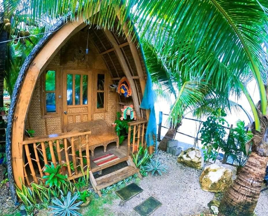 une petite maison avec une véranda et un palmier dans l'établissement Reggae Vibes De Romblon, à Agpanabat