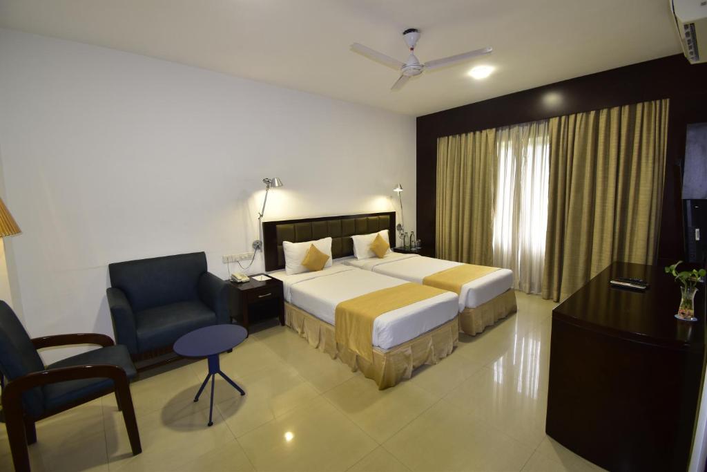 Pokój hotelowy z łóżkiem i krzesłem w obiekcie The Fern Residency, Vadgaon - Talegaon, Pune w mieście Pune