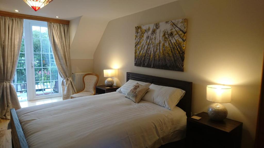 1 dormitorio con 1 cama con 2 lámparas y una ventana en Rossclare Lodge en Enniskillen