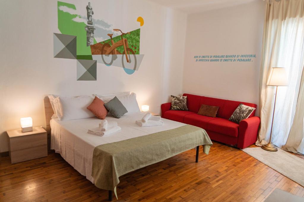 フェラーラにあるBed & Bike Ferraraのベッドルーム1室(ベッド1台、赤いソファ付)