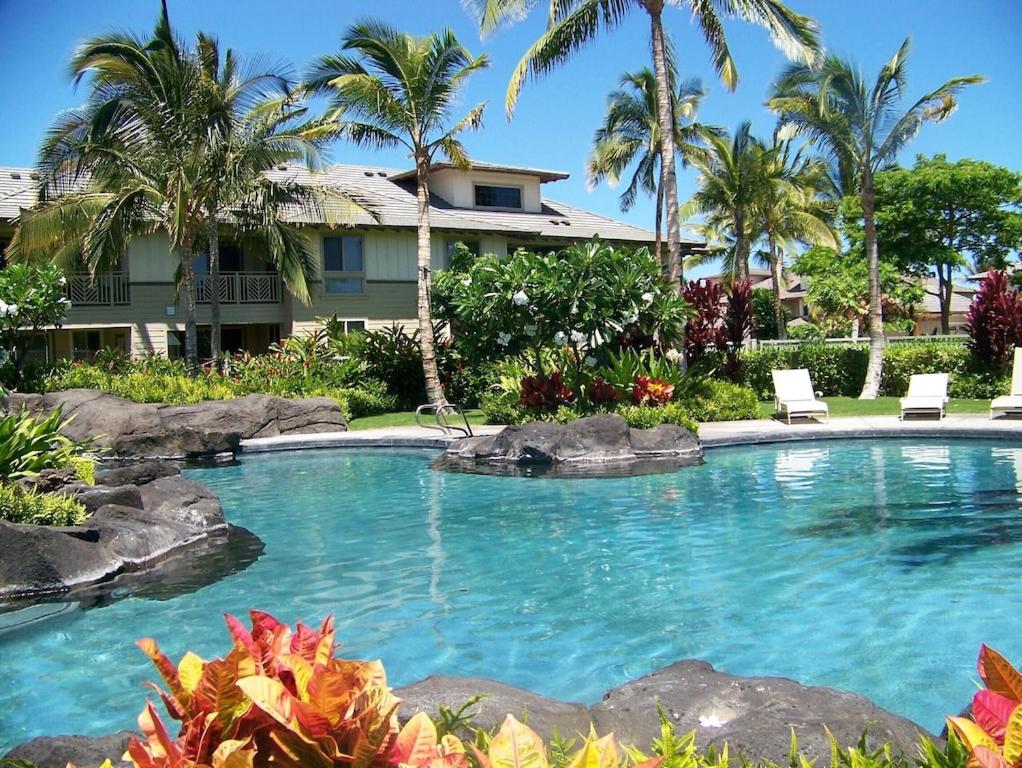 uma piscina em frente a uma casa com palmeiras em Palm Villas G1 32 em Waikoloa