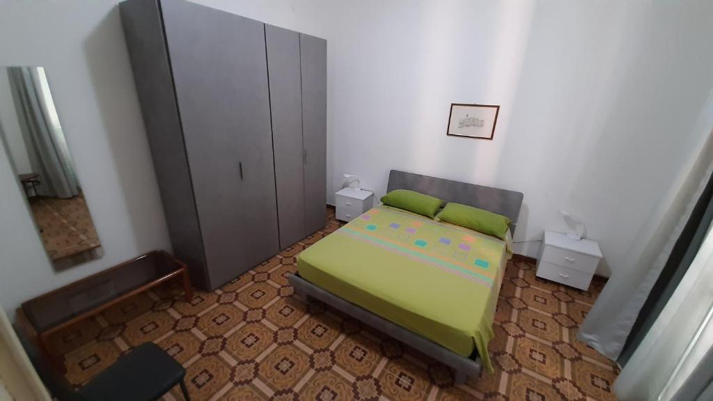 a small bedroom with a green bed in a room at Appartamento Indipendenza - Tropea centralissimo in Tropea