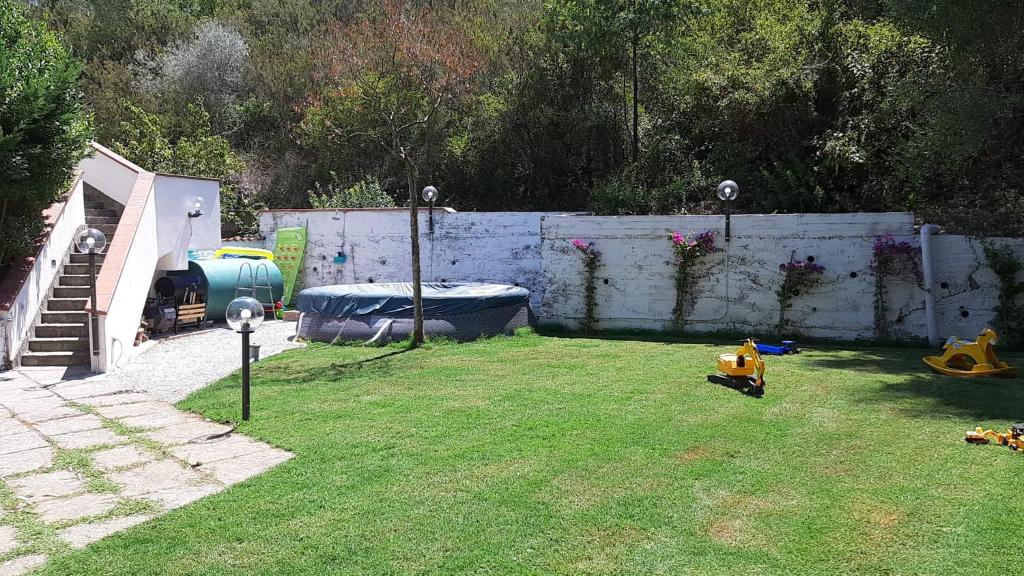 un cortile con una recinzione e un cortile con una macchinina giocattolo di VILLA LEYLAND a Laureana Cilento