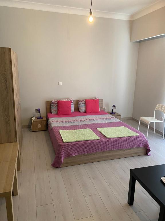 a bedroom with a large bed with pink pillows at Aris Apartment in Athens