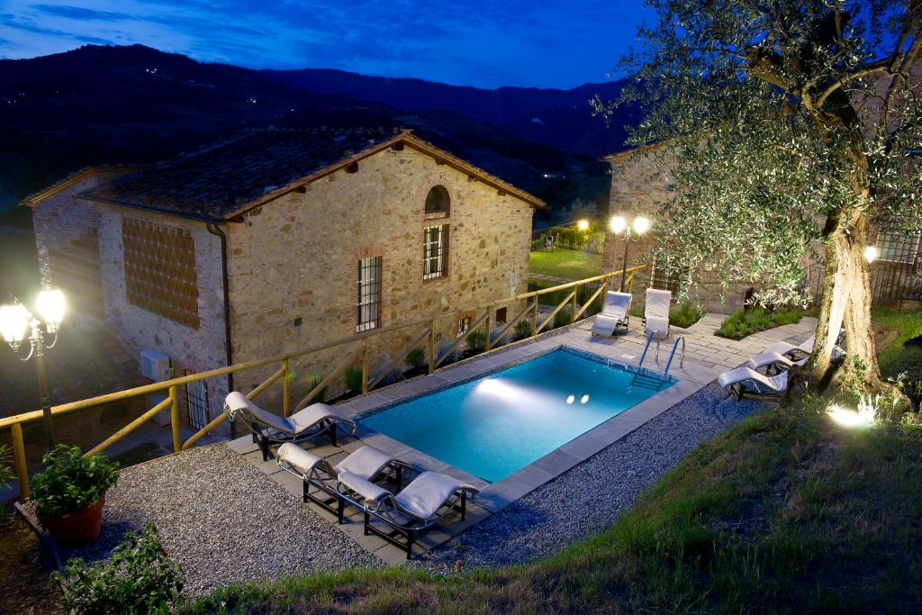 a pool in front of a building with chairs around it at Suite Accommodation in Lucca