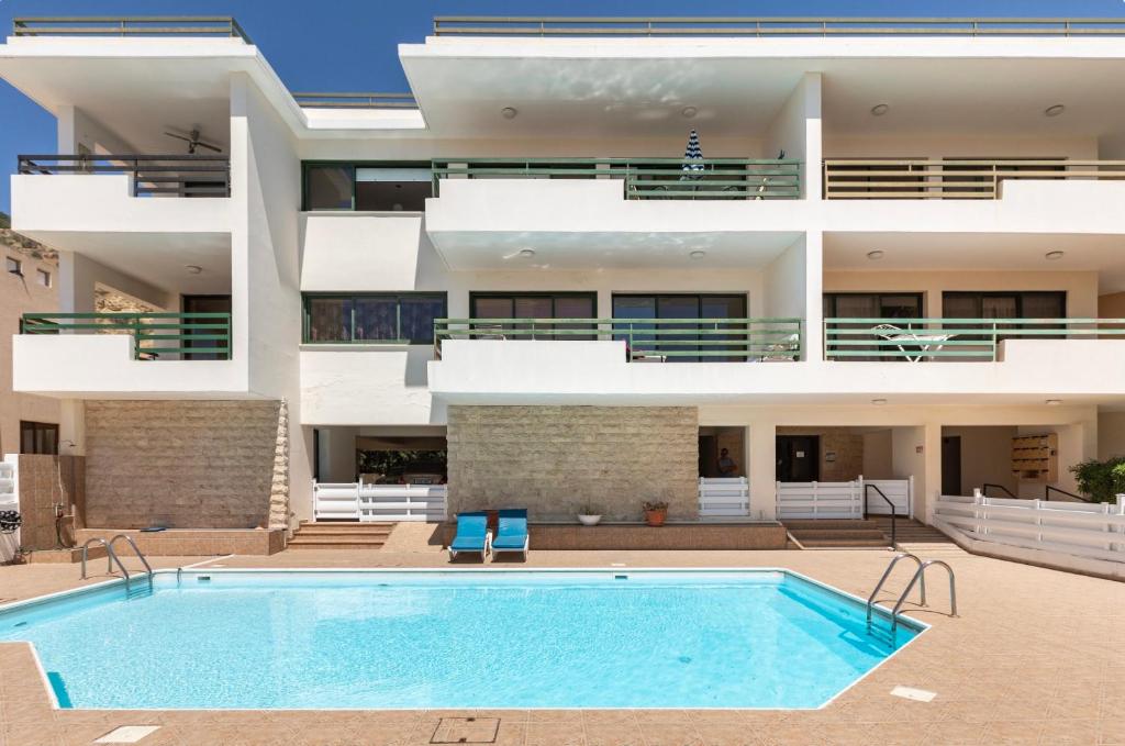 un edificio de apartamentos con piscina frente a un edificio en Mediterranean dream, en Oroklini