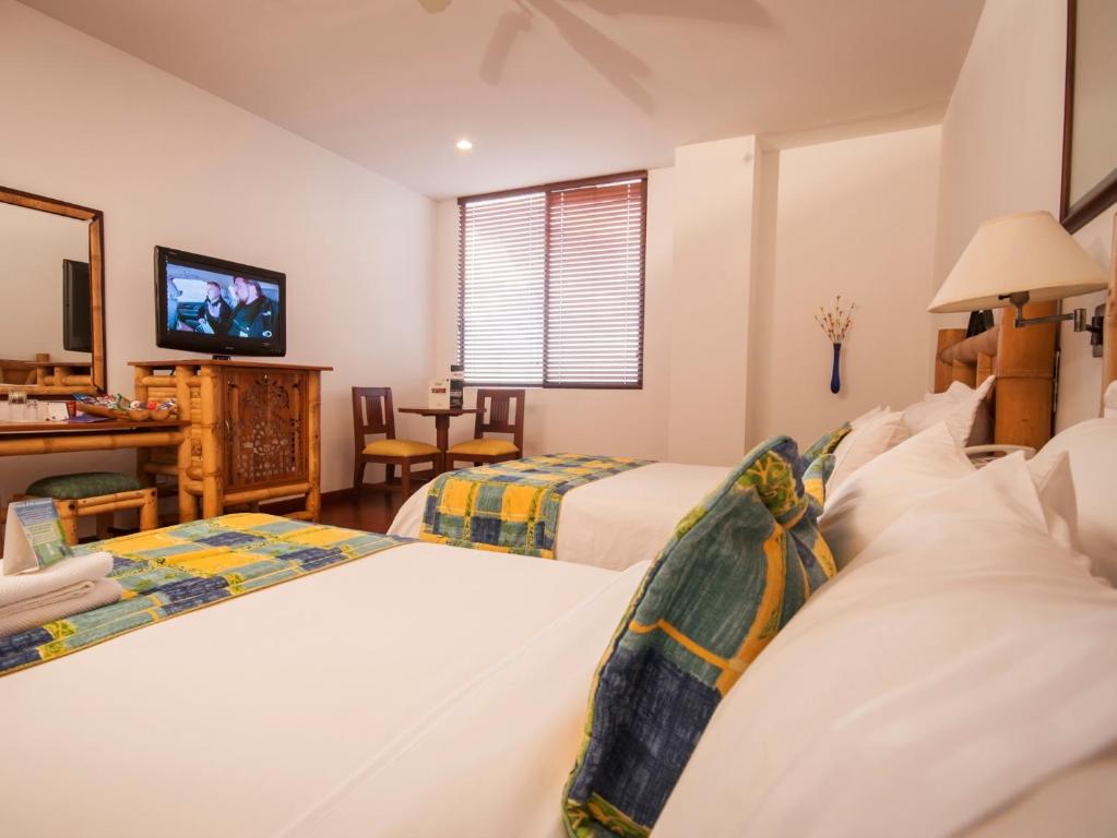 a hotel room with two beds and a television at Armenia Hotel in Armenia