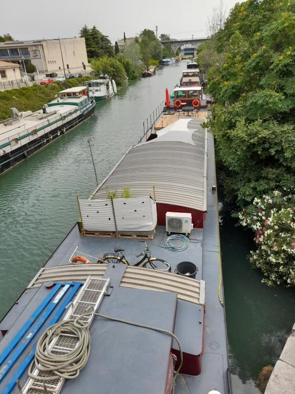 a group of boats are docked in a river at Péniche Chopine in Beaucaire