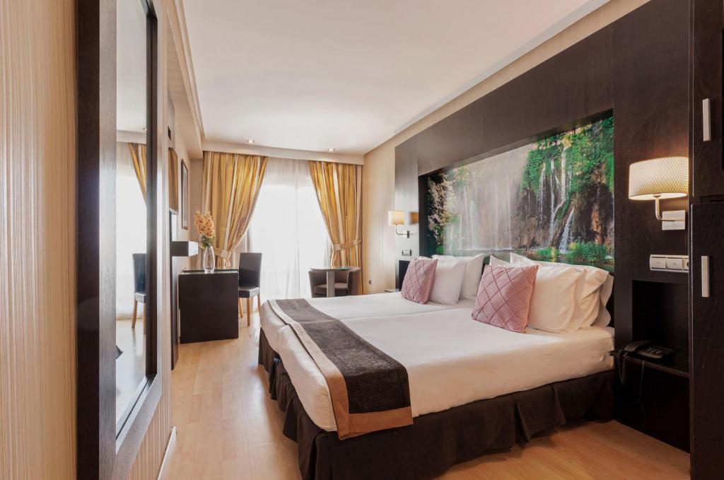 Oh Nice Ulises Ceuta في سبتة: غرفة في الفندق بها سرير و لوحة كبيرة على الحائط