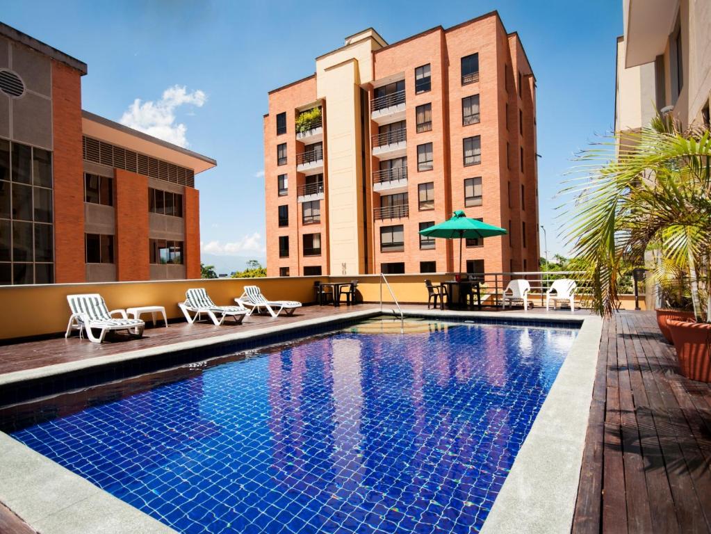 a pool with chairs and umbrellas on a building at Armenia Hotel in Armenia