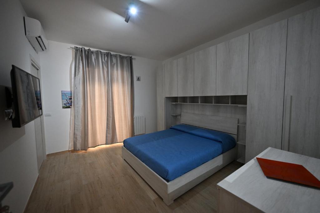 a bedroom with a blue bed and a window at eliterooms in Cagliari