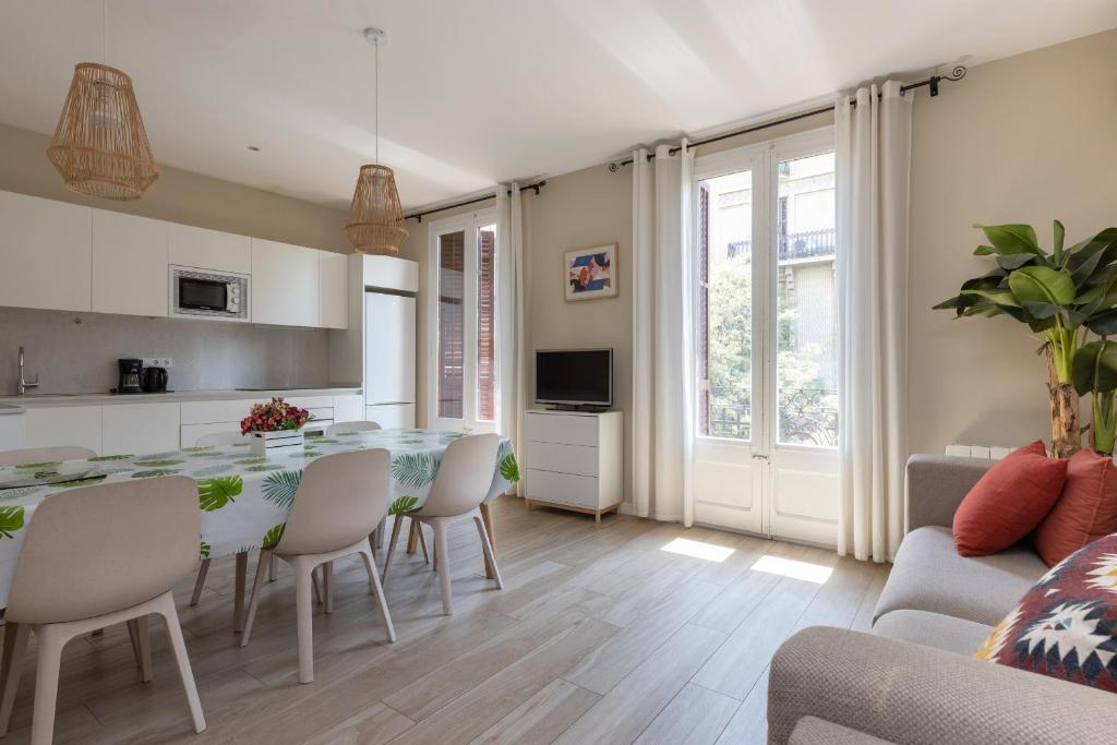 cocina y sala de estar con mesa y sillas en ApartEasy - Family 4-Bedroom Apartment en Barcelona