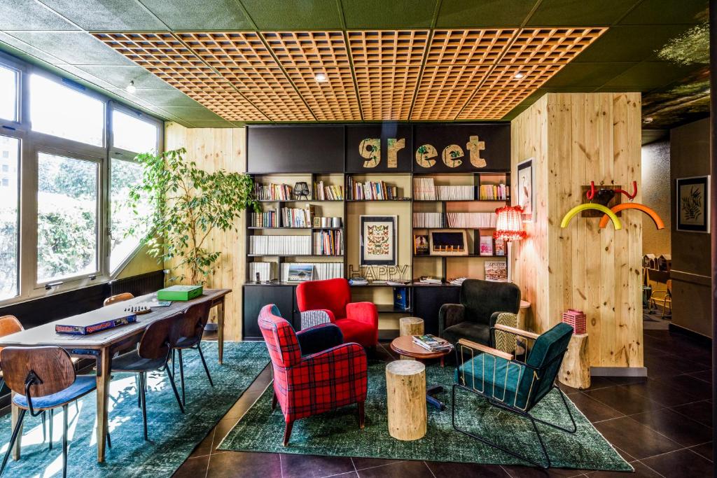 een kamer met een tafel en stoelen en een bibliotheek bij Greet Hotel Evreux Centre - Route de Normandie by Accor in Évreux