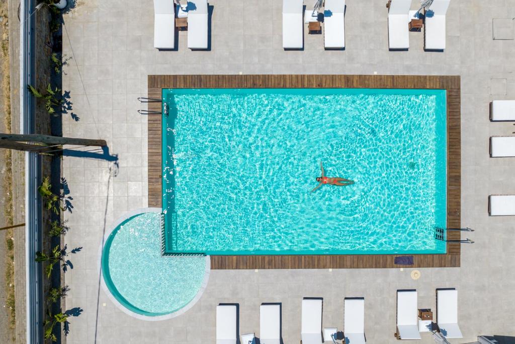 een uitzicht over een zwembad met een persoon in het water bij Kellys Luxury Apartments in Faliraki