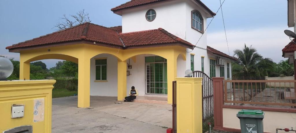 una pequeña casa de color amarillo y blanco en Inapan Keluarga Taman Indera Jitra en Jitra