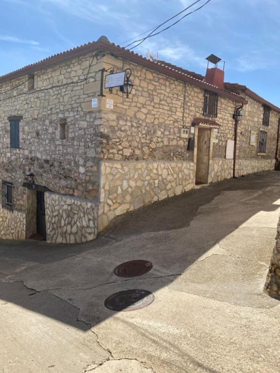 a stone building with a street in front of it at Casa Rural La Mansion in La Toba
