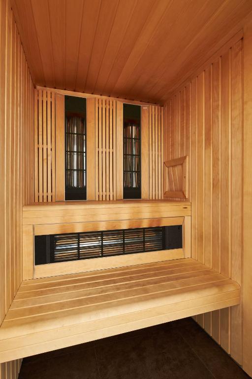 a sauna with a bench in a wooden building at Hôtel Raphael in Paris