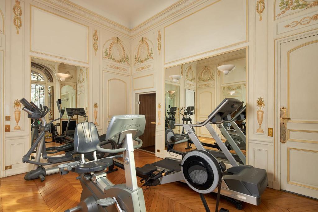 a gym with treadmills and ellipticals in a room at Hôtel Raphael in Paris