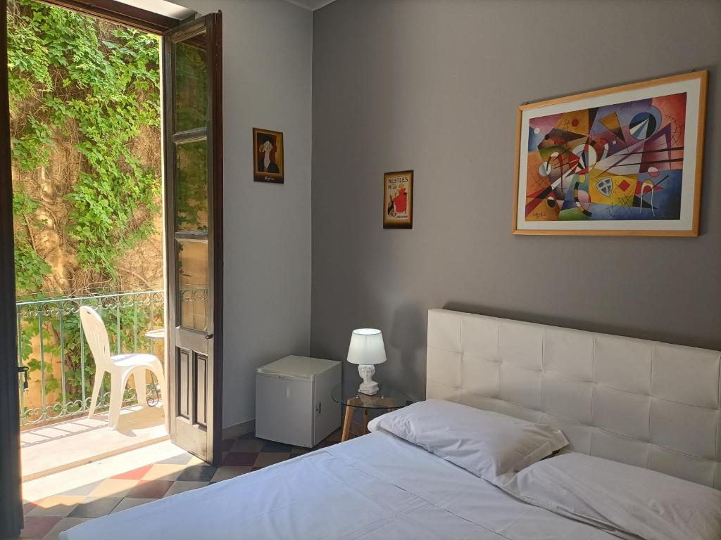 a bedroom with a bed and a view of a balcony at Ortigia Basic -Locazione Turistica in Syracuse