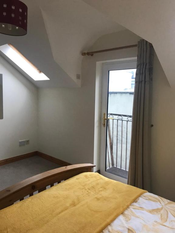 a bedroom with a bed and a window at The Beach House in Lahinch