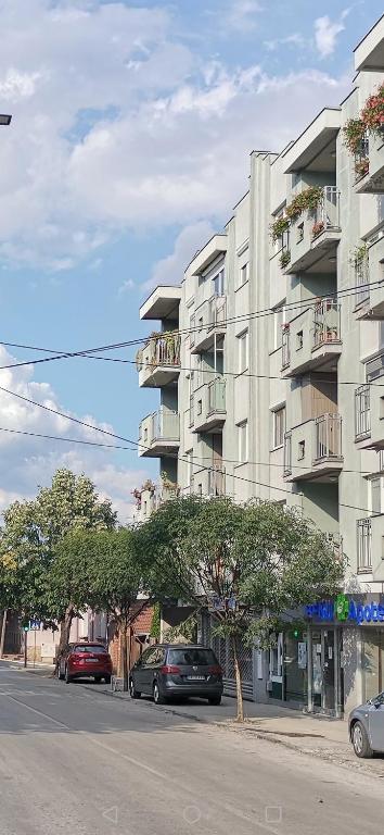 a large apartment building with cars parked in front of it at W Apartman in Gornji Milanovac