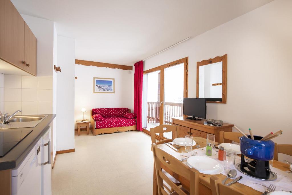 a kitchen and living room with a table and a couch at Les Balcons PROCHE PARC NATIONAL VANOISE appartements 2 pieces 6 pers MONTAGNE ALP in Termignon