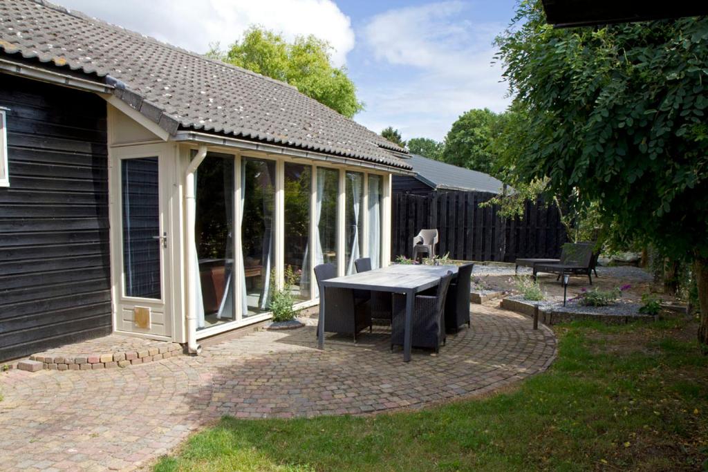 un pabellón con una mesa de picnic en un patio trasero en De Deel - Vakantiehuisje Veluwe en Ede