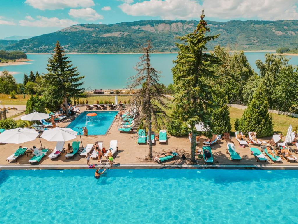 an overhead view of a swimming pool with people sitting in chairs at Hotel Radika in Mavrovo