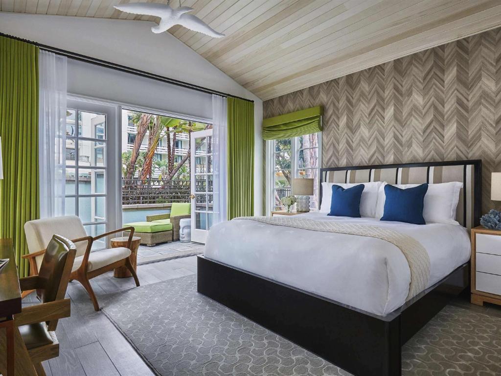 a bedroom with a large bed and a balcony at Fairmont Miramar Hotel & Bungalows in Los Angeles