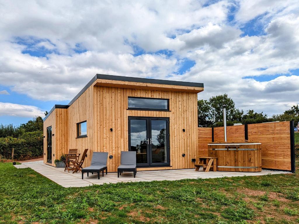 una pequeña casa de madera con sillas y mesa en The Cadeleigh, en Tiverton