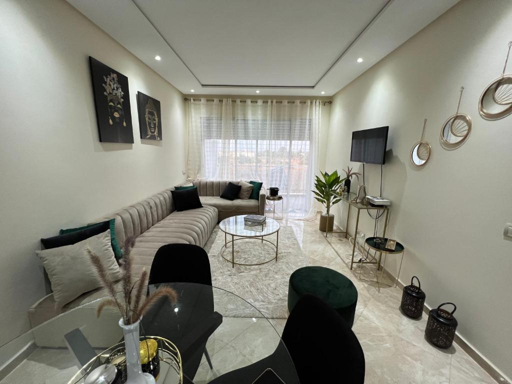 sala de estar con sofá y mesa en Résidence RAMOFLORES - Appartement avec piscine - Sidi Rahal, en Sidi Rahal