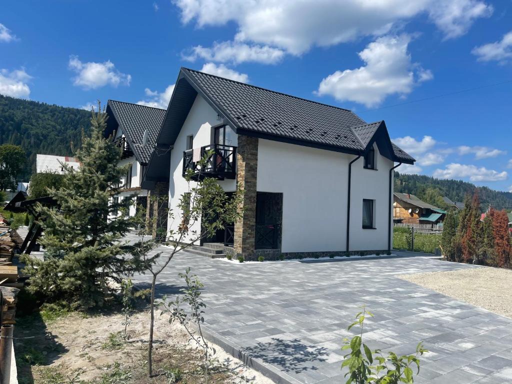 a white house with a black roof at Майя in Mykulychyn