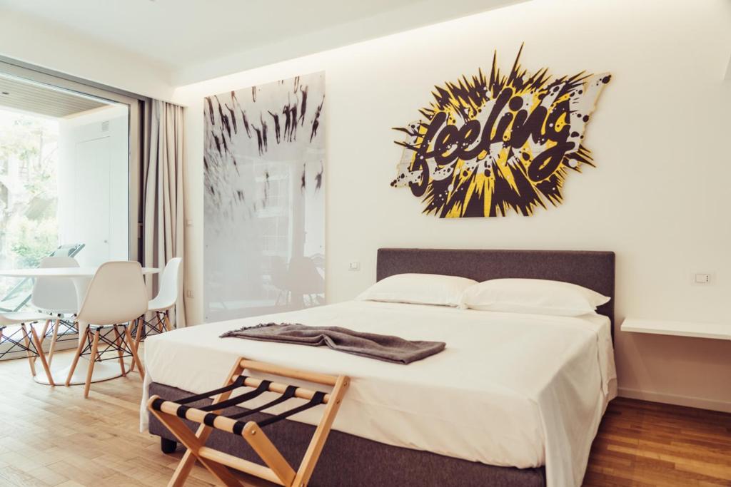 Schlafzimmer mit einem Bett, einem Tisch und Stühlen in der Unterkunft Marina Gardens Boutique&Suites in Francavilla al Mare