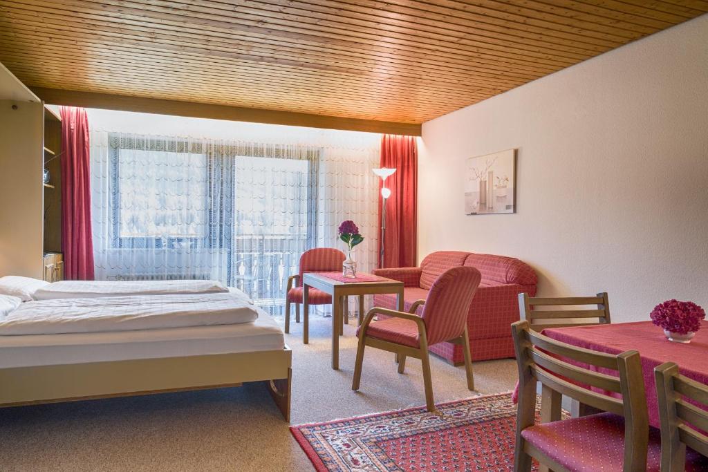 - une chambre avec un lit, une table et des chaises dans l'établissement Drei Tannen - Wohnung 06 - Apartmenthaus, Titisee, nahe Badeparadies, à Titisee-Neustadt