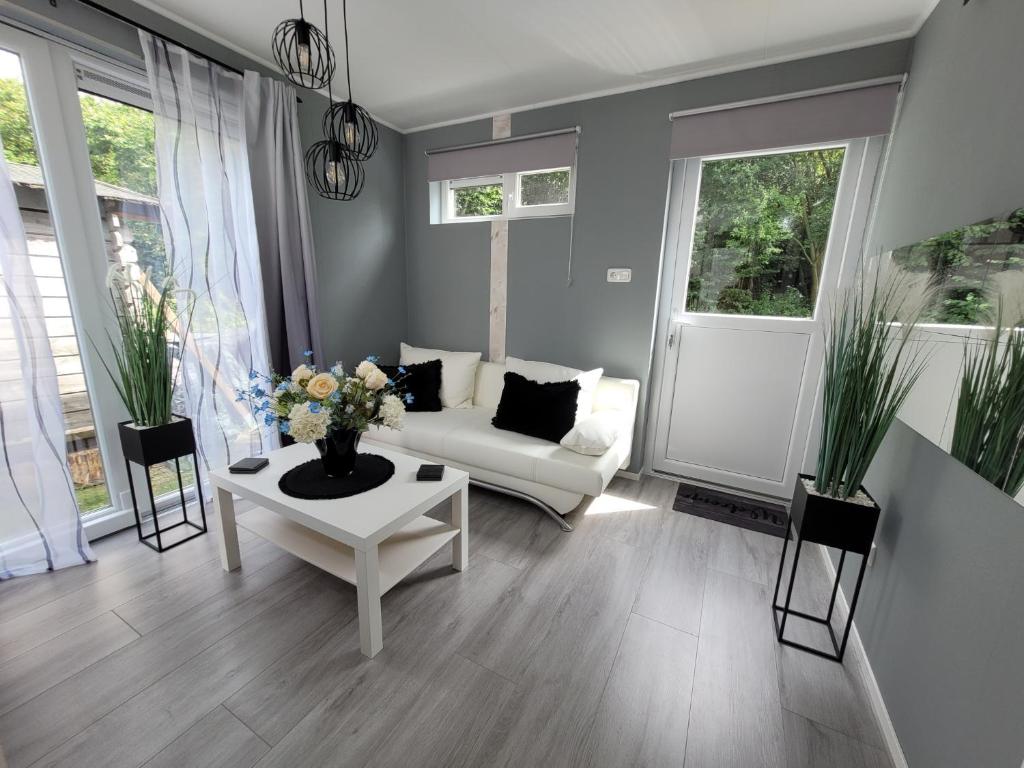 sala de estar con sofá blanco y mesa en B&B Mooi Betuwe en Tiel