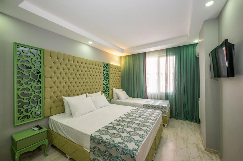Habitación de hotel con cama y TV en Green Garden Hotel en Estambul