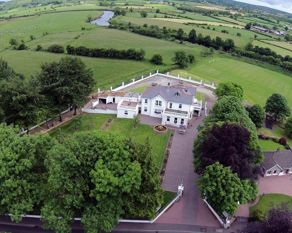 una vista aérea de una gran casa blanca con árboles en Ardgort Country House, en Castlederg