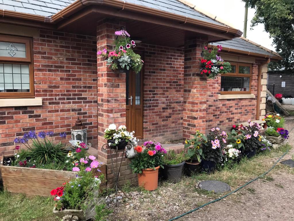 ein Backsteinhaus mit Blumen davor in der Unterkunft Grooms cottage in Thornton