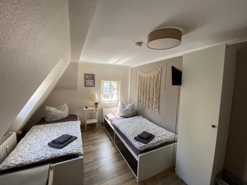 een kleine kamer met 2 bedden in een kamer bij Altstadt Pension Herborn in Herborn